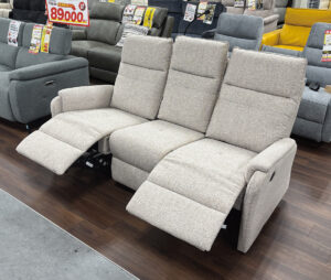 ゆったり3人掛けのファブリック電動リクライニングソファ。足先までしっかり支える電動フットレスト。無段階リクライニングで理想の角度に調整可能。中央の背もたれを倒すとテーブルに!