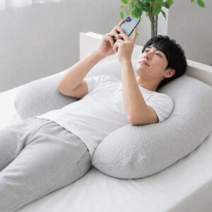 スマホ時間をもっとラクに、もっと快適に。 「包まれる安心感」と「首・腕の負担軽減」を考えた、リラックスタイム用まくらです。  横向き・うつ伏せでも使いやすい形状で、スマホを見る時の腕や首のつらさをサポート。身体をやさしく包み込む大きめサイズなので、抱き枕のように使えたり、背もたれや肘置きとしても活躍します。  ふんわりやわらかなニット生地カバー付きで、肌ざわりも快適。カバーは洗濯可能なので、清潔に使えるのも嬉しいポイントです。 寝る前のくつろぎ時間を、もっと心地よくしてくれる“ごろ寝特化型まくら”です。
